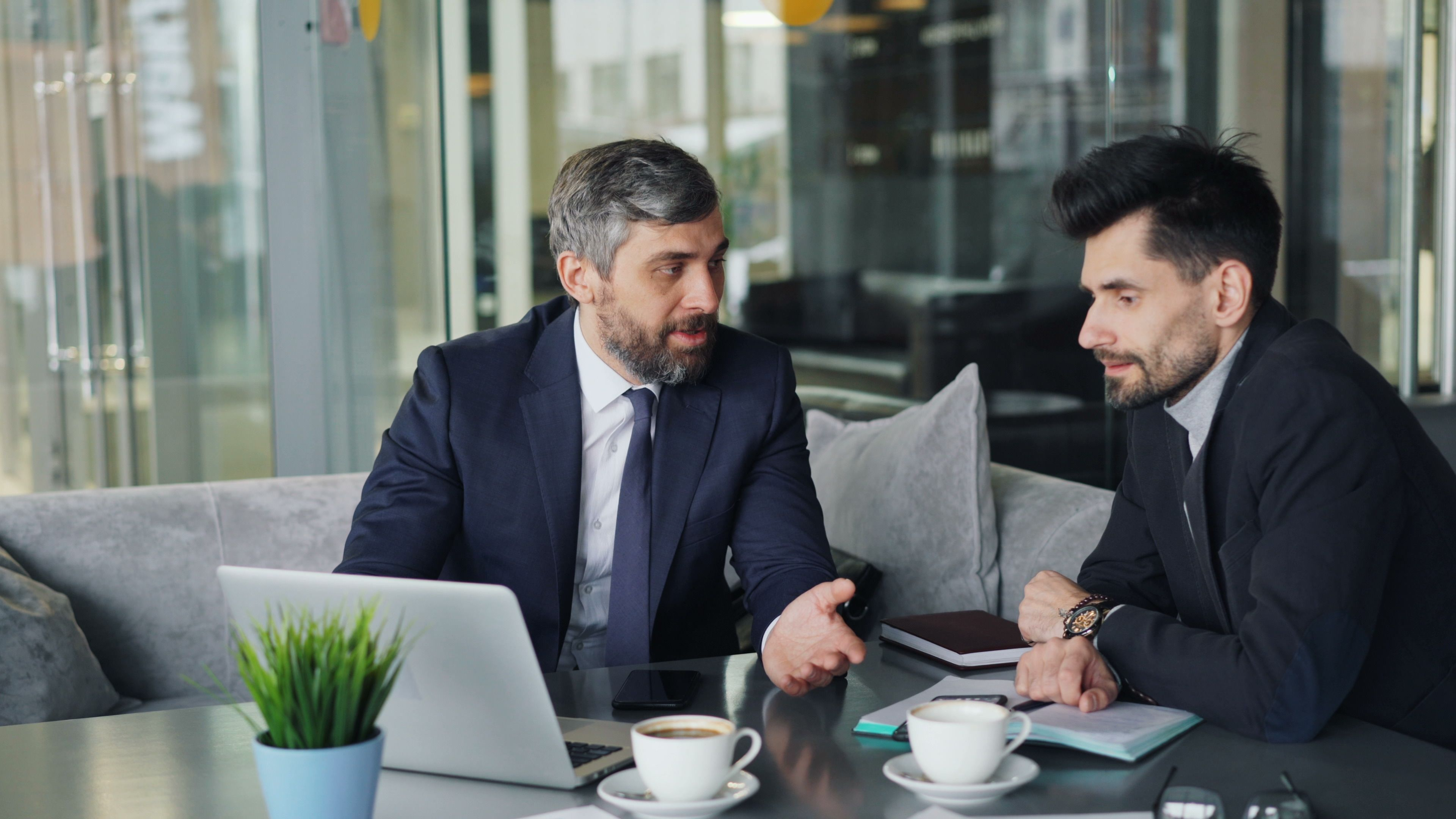 Two professionals reviewing secure investor records together in a modern conference room